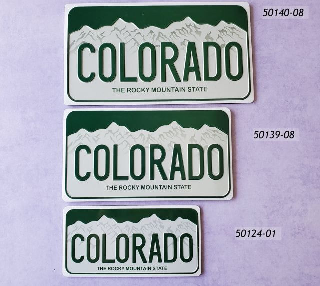 Photo of three magnets with license plate Colorado design. Biggest on top, decreasing size. 