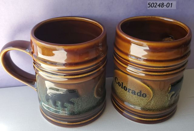 50248-01 Colorado Souvenir Tankard Mug.  Shaped like a stein with brown glaze comes with assorted blue and green center glaze and embossed black bear icons. 