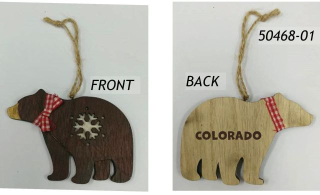 50468-01 Colorado Souvenir wood ornament shaped like a bear. Front side is dark brown and has an inset laser cut snowflake design and a red gingham bow.  Backside is lighter colored wood with a screened Colorado imprint.  Twine hanger. 